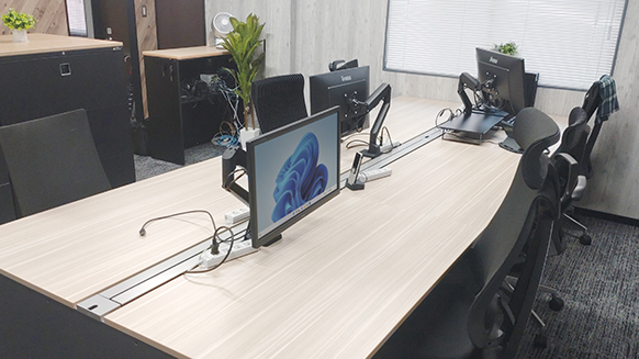 既存のミーティングテーブルに取付けられるモニターアーム